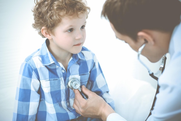 Niño médico y paciente. Médico que examina al niño pequeño. Visita médica regular en la clínica. Concepto de medicina y atención de la salud.