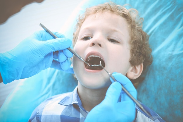 Niño médico y paciente. Un niño al que le examinaron los dientes con un dentista. Concepto de medicina, salud y estomatología.