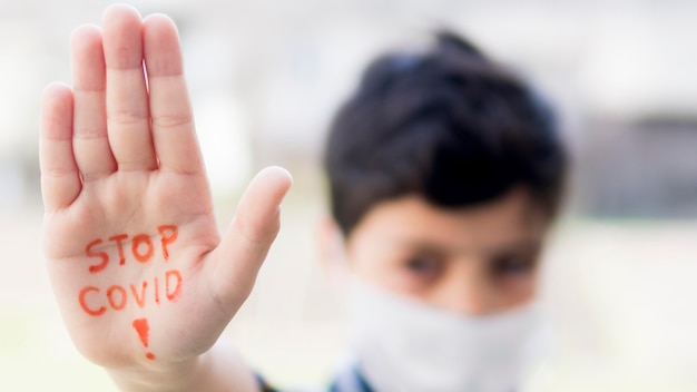 Foto niño con mensaje de detener coronavirus en mano