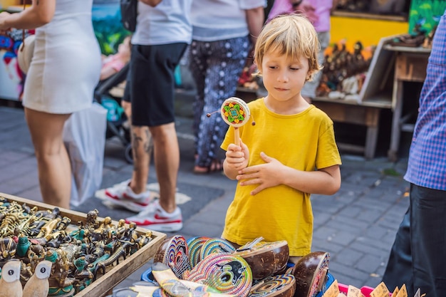 Niño en un mercado en ubud bali tienda de souvenirs típica que vende recuerdos y artesanías de bali en el
