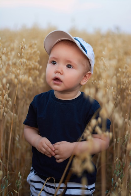 Un niño mira hacia arriba en un campo de trigo en verano