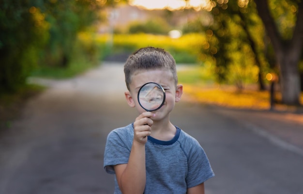 Foto niño mira con lupa enfoque selectivo naturaleza