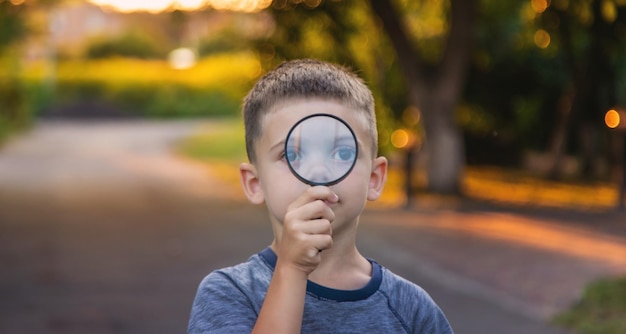 Foto niño mira con lupa enfoque selectivo naturaleza