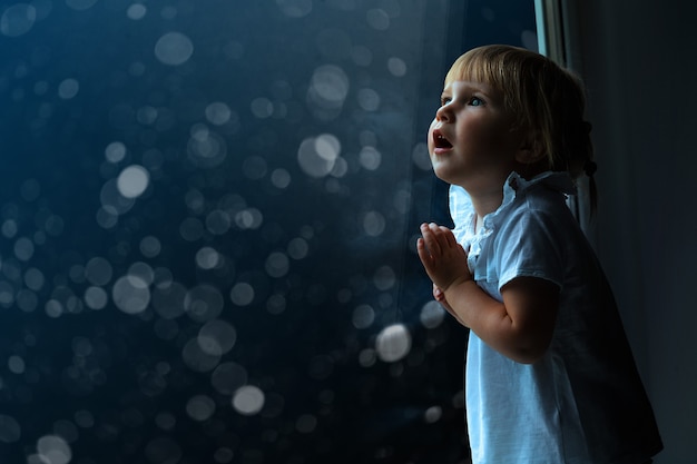 el niño mira por la ventana el día de navidad