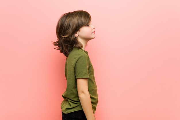 Niño mirando hacia la izquierda, de lado plantean.