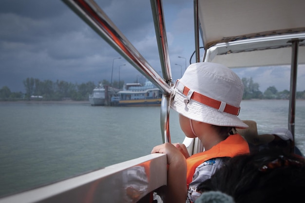 Foto niño mirando el mar en un barco