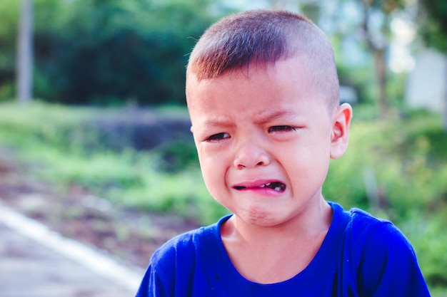 Foto niño mirando hacia otro lado mientras llora