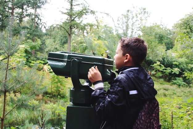 Niño mirando hacia otro lado mientras sostiene binoculares en el punto de observación