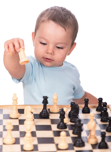 Niño mirando las piezas de ajedrez aisladas sobre fondo blanco.