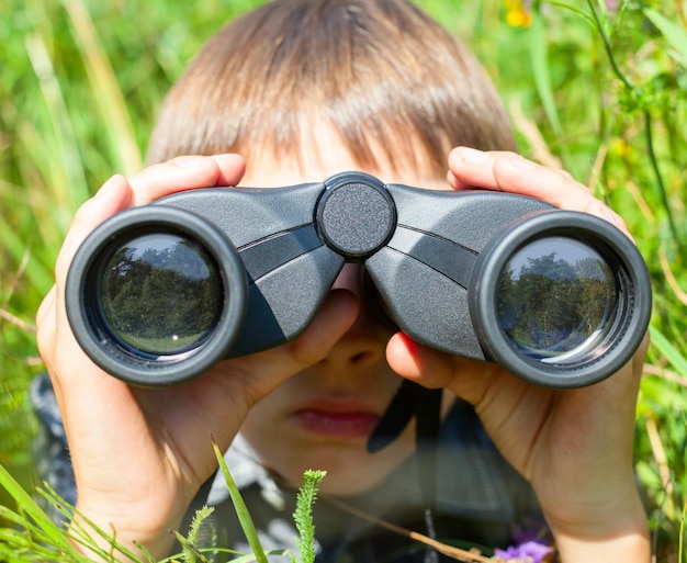 Foto niño mirando a través de binoculares