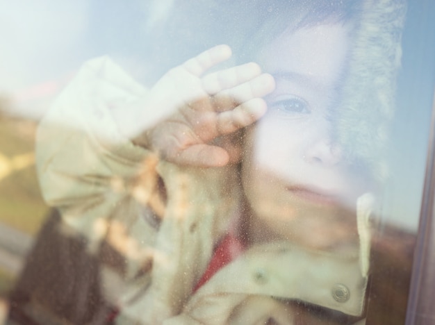 Foto niño mirando por la ventana