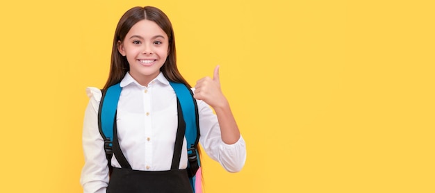 Niño con mochila escolar pulgar arriba feliz jovencita llevar mochila Retrato de colegiala estudiante estudio banner encabezado Escuela niño cara copyspace