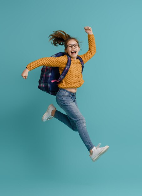 Foto niño con mochila sobre fondo de color