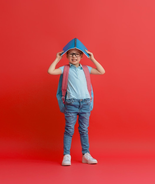 Niño con mochila sobre fondo de color