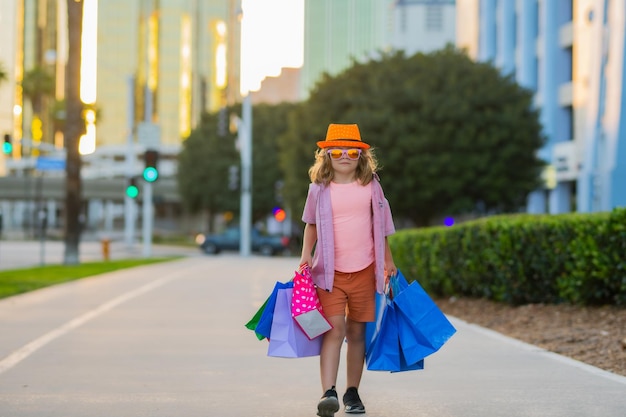 Niño de moda con bolsa de compras al aire libre niño pequeño comprador