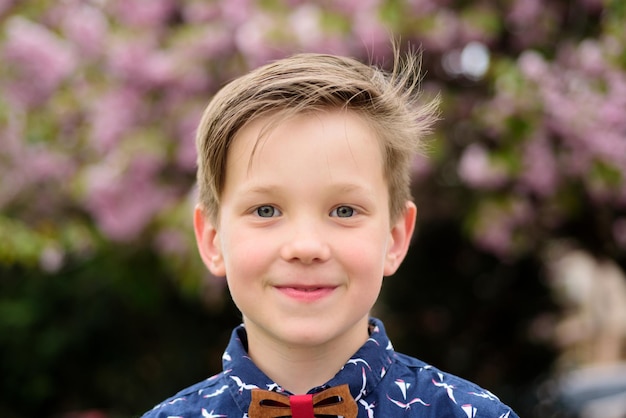 Niño de moda con camisa y pajarita retrato de un niño en el parque de primavera al aire libre de primer plano cara niño