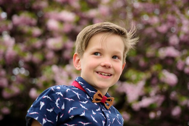 Niño de moda en camisa y pajarita retrato de primer plano al aire libre de niños divertidos cara niño de verano al aire libre