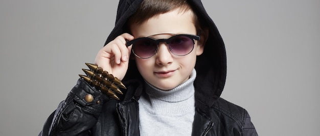 Niño de moda con capucha y gafas de sol