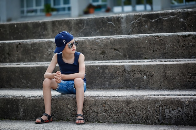 Niño de moda en gafas de sol y gorra. Infancia. Hora de verano