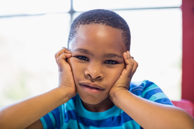 Niño molesto sentado en el aula