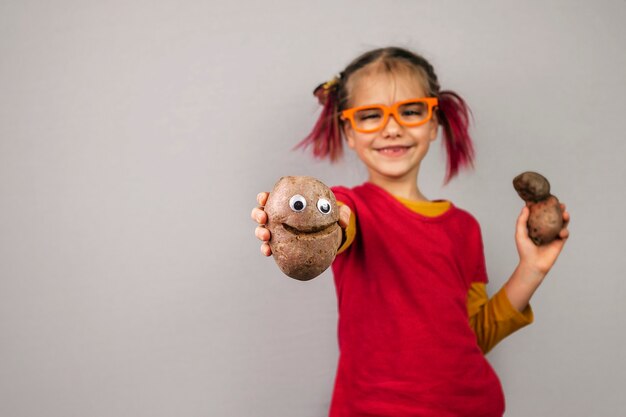 Niño monstruoso sostiene frutas y verduras deformes de colores incorrectos, concepto de desperdicio de alimentos