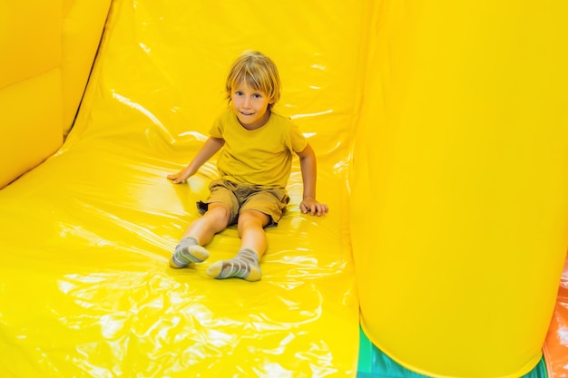 El niño monta con un tobogán inflable.