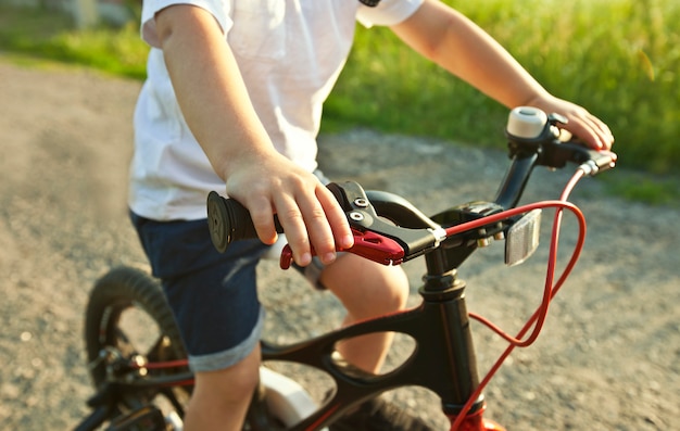 Niño montando la bicicleta por la carretera de asfalto