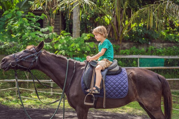 Niño montando a caballo realizando ejercicios a caballo