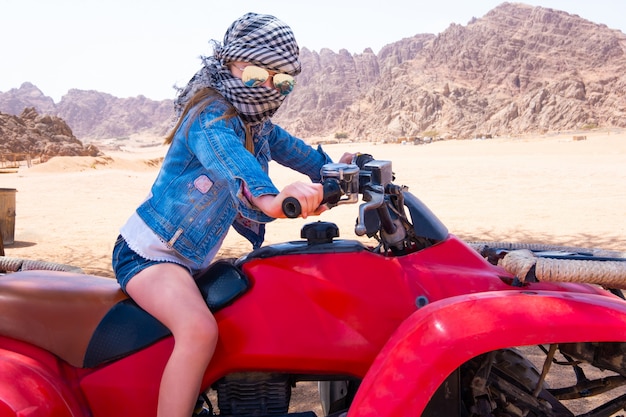 Niño montando en quad en el desierto