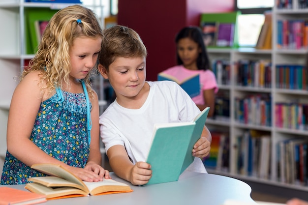 niño mostrando libro a compañero de clase