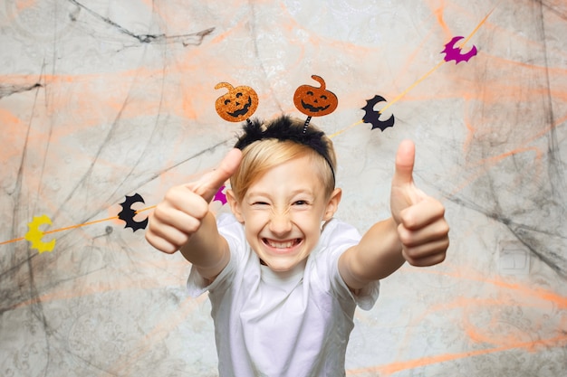 niño muestra caras divertidas para la cámara en Halloween