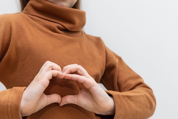 El niño muestra el corazón con las manos en primer plano