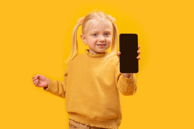 Niño muestra teléfono negro con pantalla en blanco