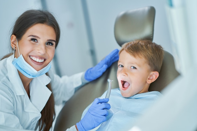 Niño y mujer dentista en la oficina de dentistas