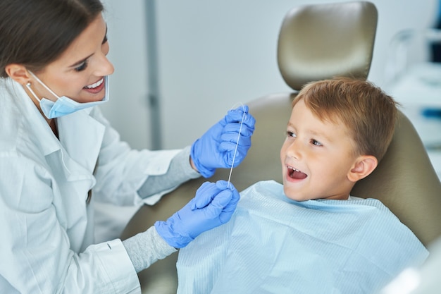 Niño y mujer dentista en la oficina de dentistas