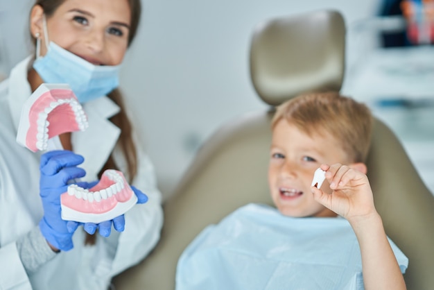 Niño y mujer dentista en la oficina de dentistas