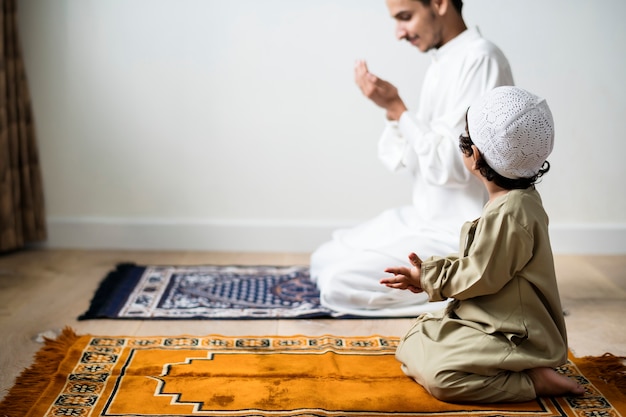 Niño musulmán aprendiendo a hacer Dua a Alá.