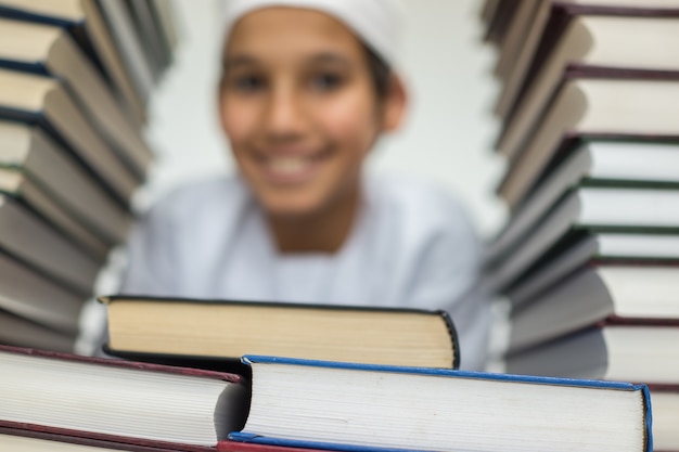 Foto niño musulmán árabe en la biblioteca con libros