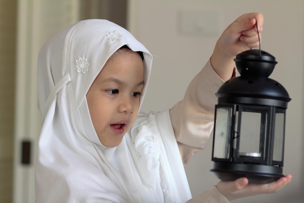 Niño musulmán preparando linterna para el mes sagrado del ramadánNiño musulmán asiático en traje tradicional feliz