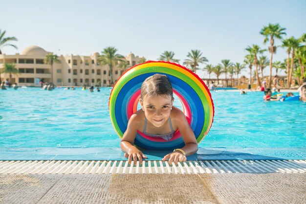 El niño nada y se zambulle en la piscina. Enfoque selectivo.