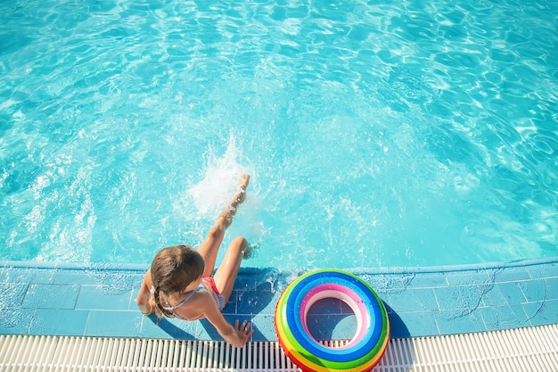 El niño nada y se zambulle en la piscina. Enfoque selectivo.