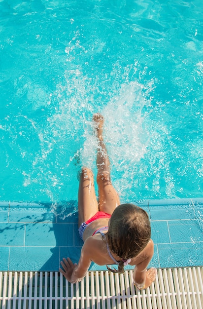 El niño nada y se zambulle en la piscina.