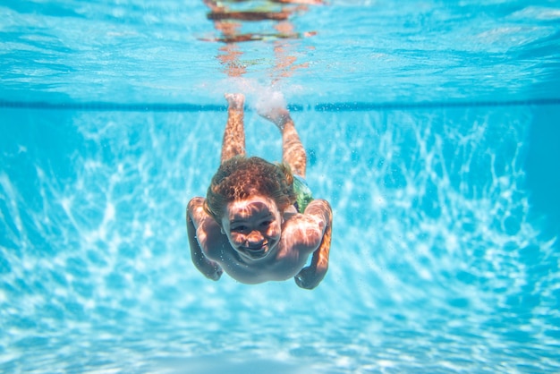 Niño nadando en la piscina bajo el agua