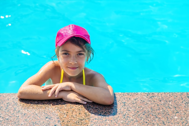 Foto el niño está nadando en la piscina. enfoque selectivo.