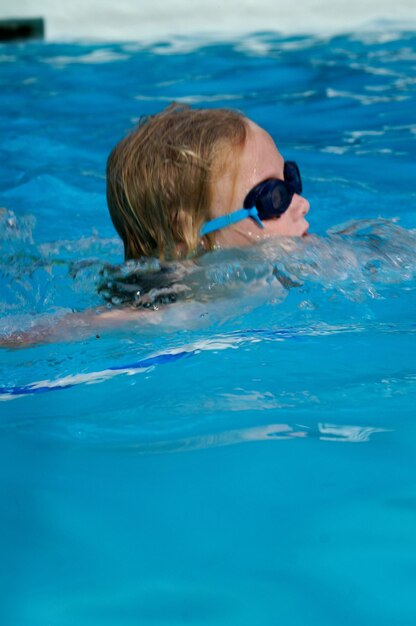 Foto niño nadando en la piscina