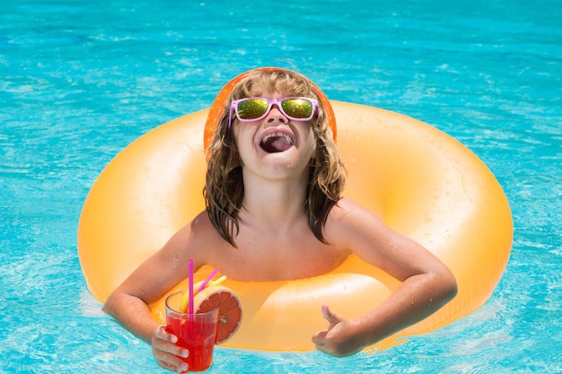 Niño nadar en la piscina en el día de verano beber jugo cóctel vacaciones de verano y concepto de vacaciones los niños nadan