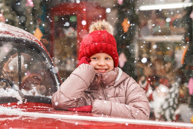 El niño de Navidad disfruta de la ventana de la tienda de Navidad de invierno. Las compras navideñas son felices para los niños