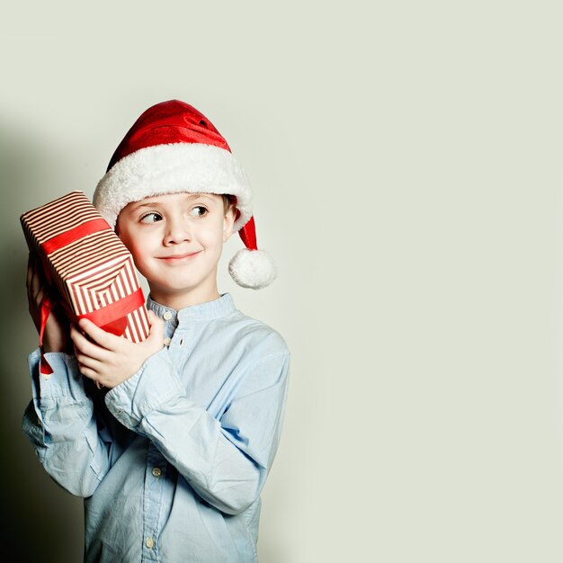 Foto niño de navidad y regalo de navidad. ¿qué hay en la caja de regalo?