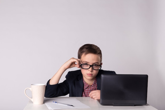 Foto niño de negocios cansado joven sentado en la mesa