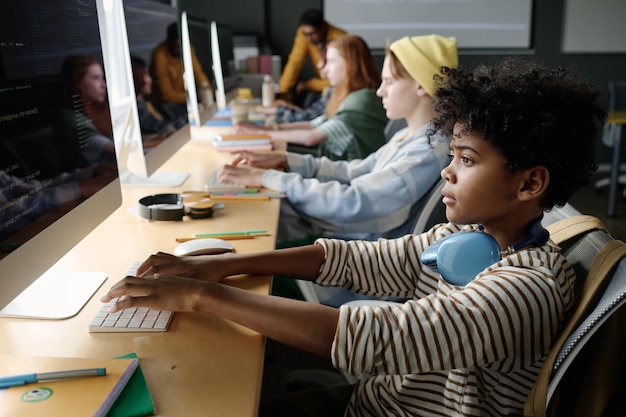 Niño negro centrado en la codificación en clase